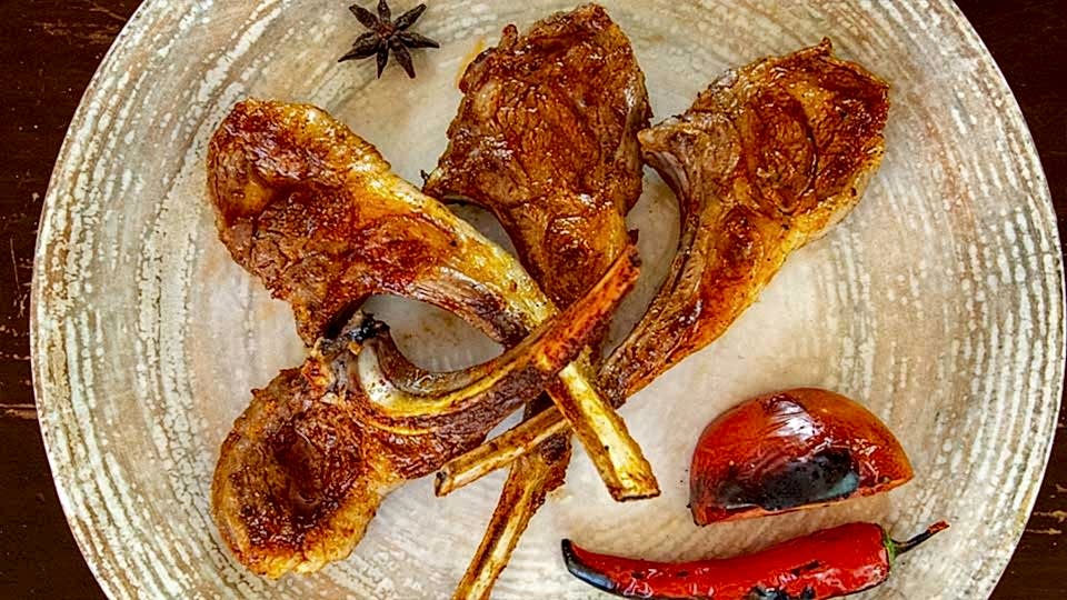 Kömür ateşinde ızgara edilmiş kuzu pirzola, yanında közlenmiş domates ve biber ile porsiyon sunum – Adana Dede Kebap Steak Burger Tatlı Kasap